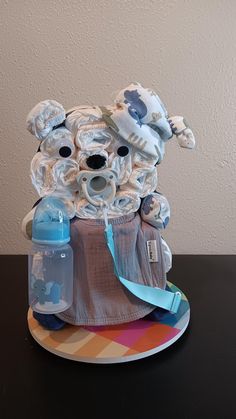 a diaper cake that is sitting on top of a table with a baby bottle