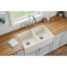 a double sink in a kitchen with wooden counter tops