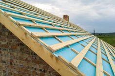 the roof of a brick building that is being constructed with wood and blue tarp