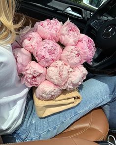 a bunch of pink peonies are sitting in the back seat of a car