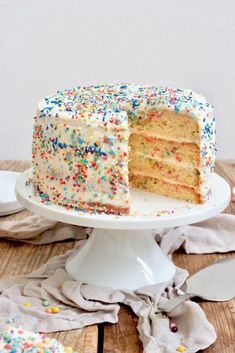 a cake with white frosting and sprinkles is cut from the plate