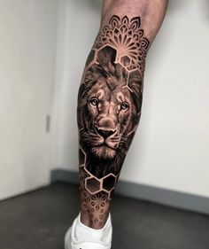 a man's leg with a lion and flower tattoo design on the left calf