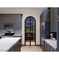 a kitchen with an arched glass door and marble counter tops