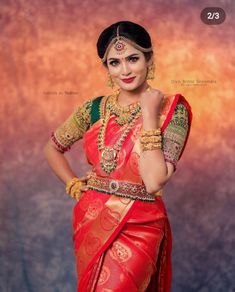 a woman in a red and gold sari with her hands on her hips, posing for