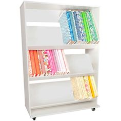 a white book shelf filled with lots of different colored books and papers on top of it