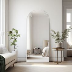 a living room with a couch, mirror and plant in it's centerpiece