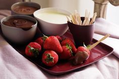 strawberries on a plate with dipping sauce and chocolate