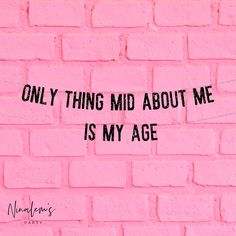 a pink brick wall with the words only thing mid about me is my age written on it