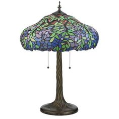 a lamp that is sitting on top of a wooden stand with a blue and green glass shade