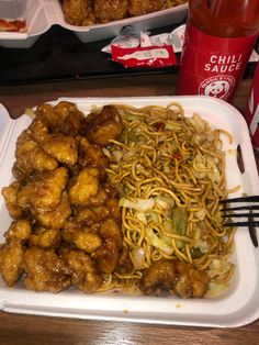 a tray filled with chicken and noodles on top of a table