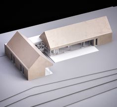 an architectural model of a house on top of a white surface with train tracks in the foreground