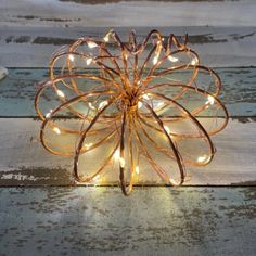 a metal object with lights on it sitting on top of a wooden table in the snow