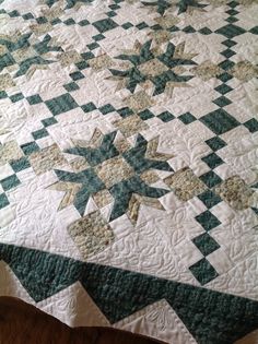 a bed with a green and white quilt on it