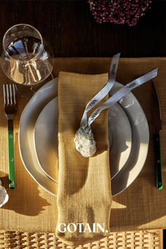 A Christmas table setting featuring mustard woven linen napkins, dried floral centerpieces with ribbon, and rustic decor on a wooden table.