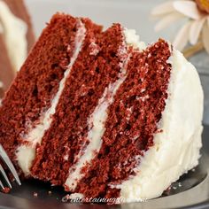 a slice of red velvet cake with white frosting