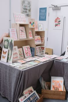 there are many greeting cards on display at the table and in front of them is a wooden box