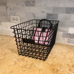 a shopping basket sitting on top of a kitchen counter next to a tile backsplash