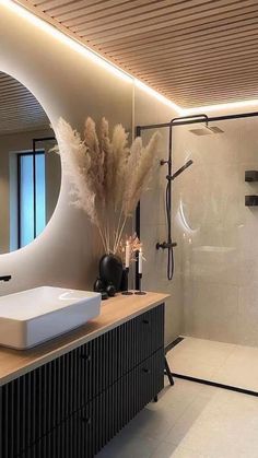 a bathroom with a sink, mirror and shower in it's centerpieces