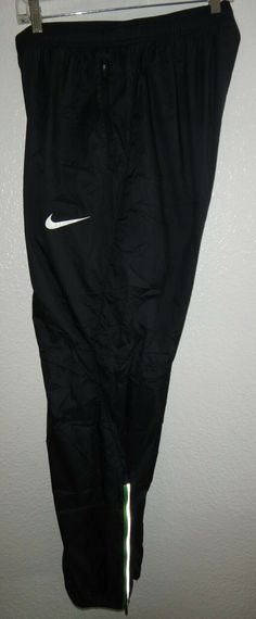 a pair of black nike pants hanging on a wall