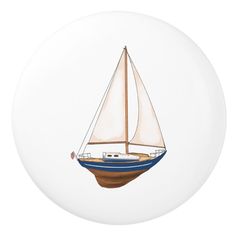 a blue and white sailboat on a white background ornament with brown trim