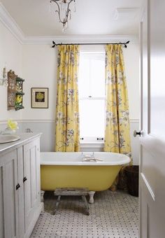 a yellow bath tub sitting next to a window in a bathroom