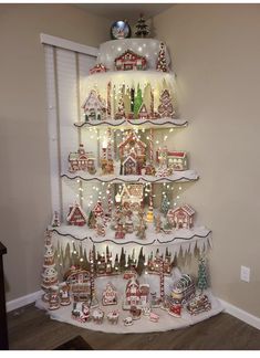 a christmas tree made out of shelves with lights and ornaments on it's sides