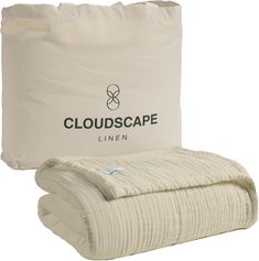 the cloudscape linen blanket is next to a bag