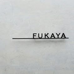 the word fukaya written in black on a white wall