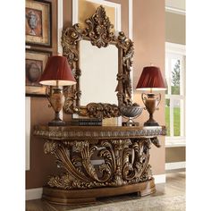 an ornate console table with two lamps and a mirror