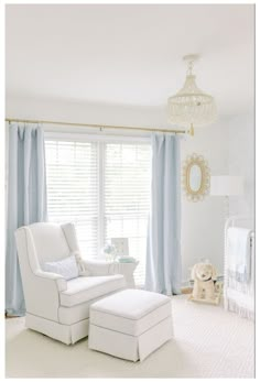 a baby's room with white furniture and blue drapes