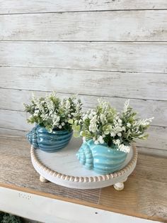 two blue vases with white flowers on a table