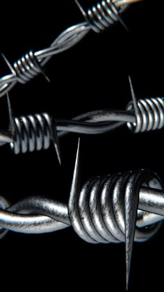 closeup of barbed wire and nails on a black background