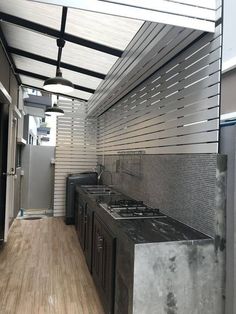 an outdoor kitchen with stainless steel appliances and wood flooring is seen in this image