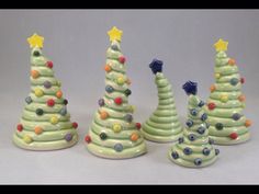 three small ceramic christmas trees in different colors and sizes, with stars on the top