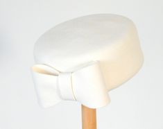 "A white pillbox hat made of 100% wool felt is handmade just for you! It is chic, light and a 50's classic dress hat for weddings, cocktail parties or the races. Diameter:  19 cm= 7\" Attaches with a black eleastic that is worn in the back of the head under the hair. AVAILABLE IN ABOUT 20 OTHER COLORS. For pillbox hats in other shapes and materials: https://www.etsy.com/il-en/shop/RanaHats?ref=seller-platform-mcnav&page=1#items Do not hesitate to call me with questions." Pillbox Hat With Veil Wedding, 50s Pillbox Hat, 1940s Pillbox Hat, Pillbox Hat Hairstyles, 50s Hats, White Pillbox Hat, Pillbox Hats, Spider Lady, Pill Box Hat