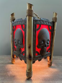 two skulls are in the middle of a wooden frame with red light coming from behind them