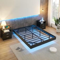 a bed frame is lit up with blue lights in the middle and two nightstands on either side