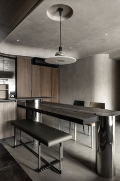 a modern kitchen with an island table and bench