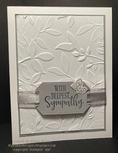 a white card with a silver ribbon and a tag that says, with deepest sympathy