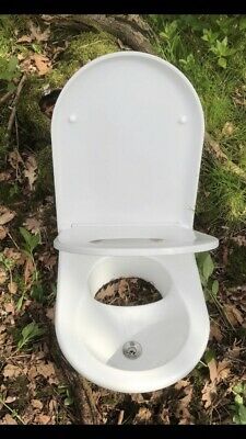 a white toilet sitting in the middle of some grass