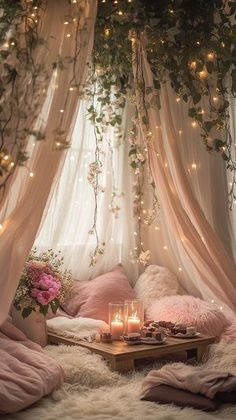 a living room filled with lots of pillows and blankets under a canopy covered in lights