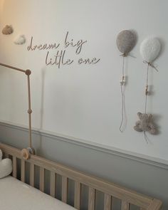 a baby crib with stuffed animals hanging on the wall next to it's bed