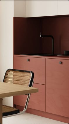 a table and chairs in a room with cupboards on the wall behind them,