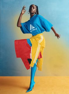 a woman in blue shirt and yellow skirt dancing