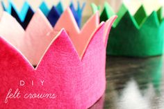 a crown made out of felt crowns sitting on top of a wooden table with the words diy felt crowns written in white