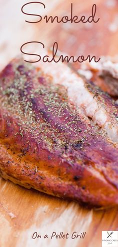 a piece of grilled salmon on a wooden cutting board with the words smoked salmon