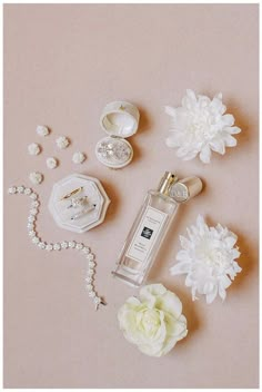 white flowers and jewelry on a pink background