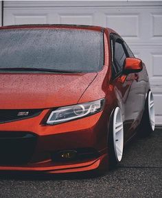 an orange car parked in front of a garage door