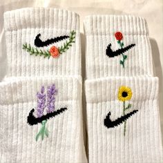 three pairs of white socks with embroidered flowers on them