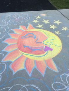 a chalk drawing of a sun and stars on the sidewalk